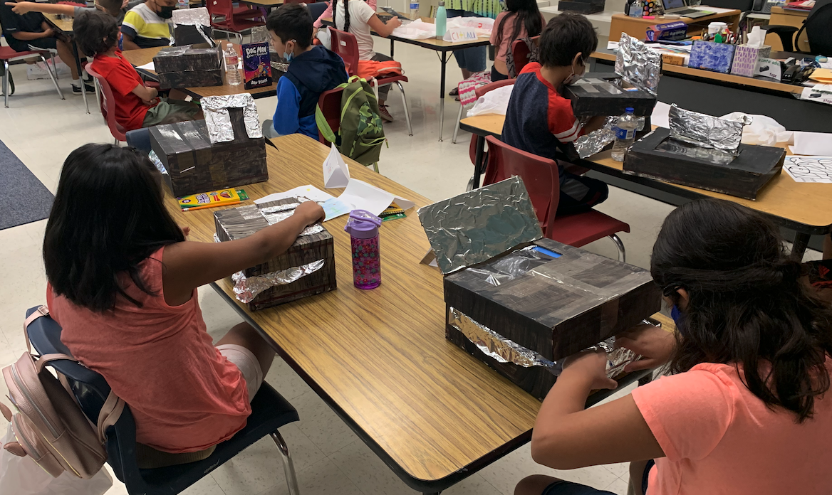 students working on creating solar ovens using boxes and foil